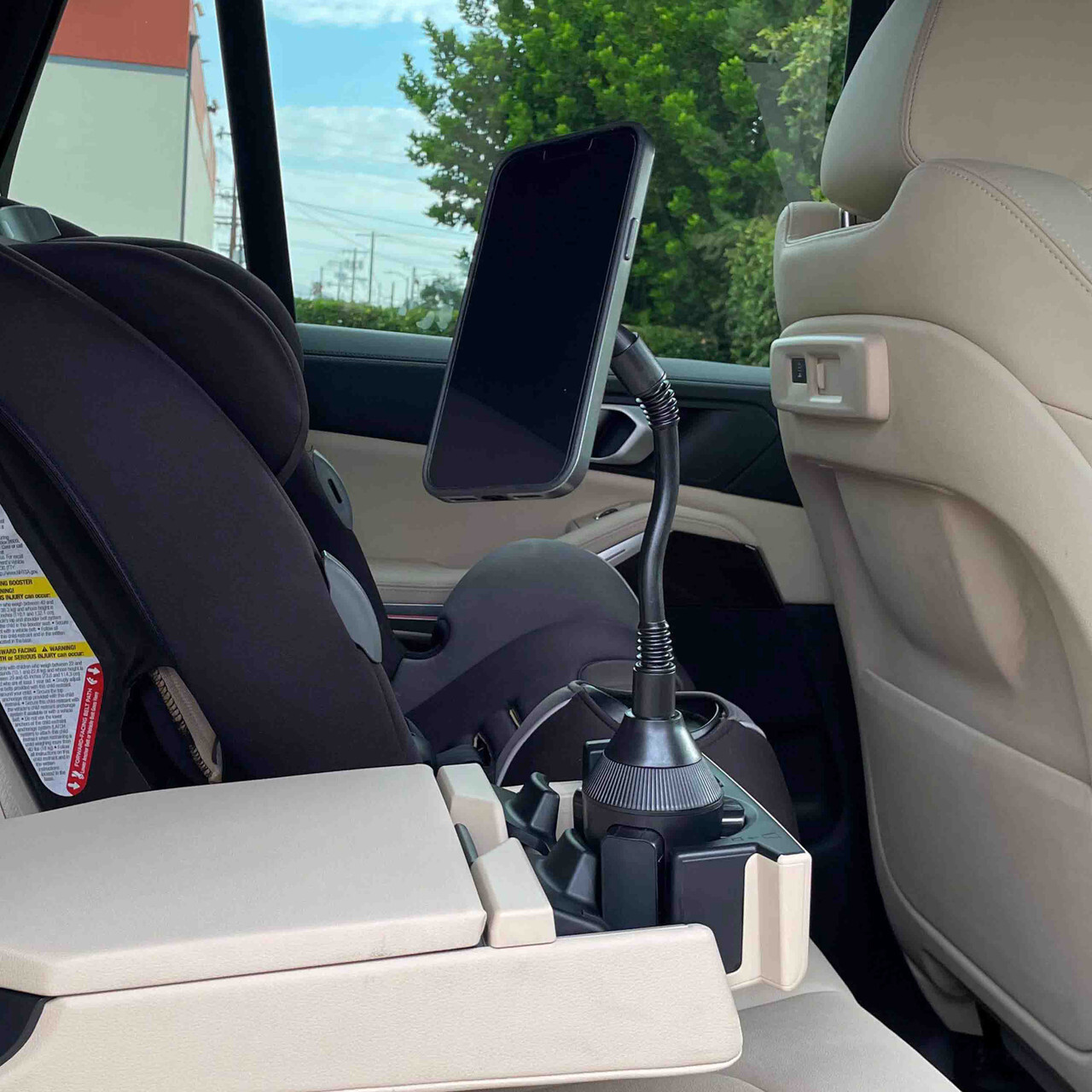 Flexible cup holder phone mount installed in car rear seat for hands-free viewing.
