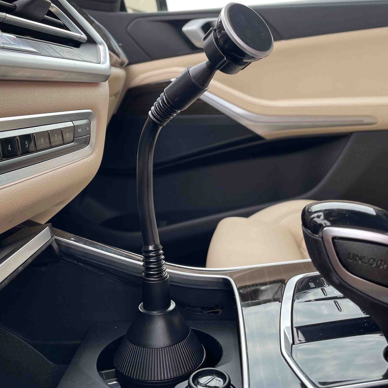 Flexible magnetic cup holder phone mount positioned in car center console.