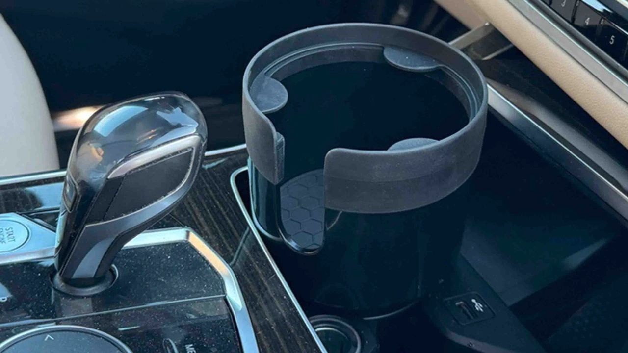 Expandable car cup holder insert placed in center console for larger cups